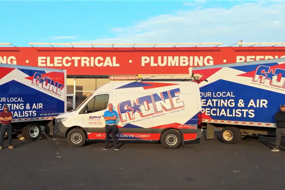 Three A-One staff standing by a Sprinter van and two box trucks at the Pasco shop